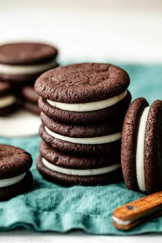 chocolate cookies with white frosting stacked on top of each other next to a wooden spoon