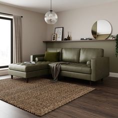 a living room with a green couch and rug