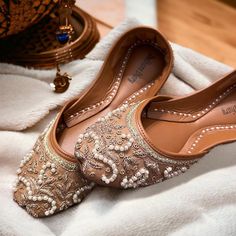 Introducing our exquisite Bronze Bridal Khussa, a true masterpiece crafted to enhance your special day with elegance and comfort. Meticulously handcrafted with genuine leather and adorned with high-quality silk, these Khussa shoes are the epitome of luxury and style. Each pair is a testament to the artistry of our skilled artisans, featuring intricate cora and beadwork that adds a touch of regal charm. But beauty is not the only aspect we've considered; we've prioritized your comfort as well. Th Elegant Open Toe Wedding Flats, Elegant Open Toe Flats For Wedding, Elegant Gold Open Toe Flats, Elegant Open Toe Gold Flats, Elegant Slip-on Ballet Flats For Wedding, Elegant Handwork Flats, Festive Cut Dana Flats For Diwali, Gold Handwork Flats For Party, Elegant Gold Flats With Handwork