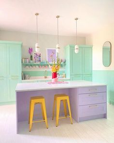 a dog is laying on the floor in front of a kitchen island with stools