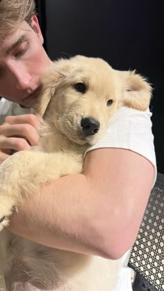 a man holding a puppy in his arms