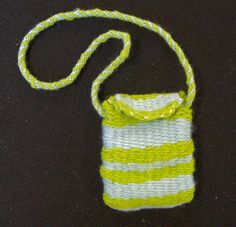 a green and white striped bag sitting on top of a black table next to a string