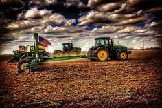 two tractors in a field with an american flag