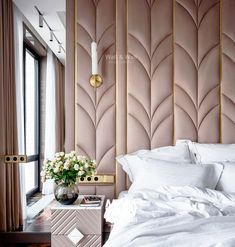 a bed with white sheets and pillows in front of a pink wallpapered headboard