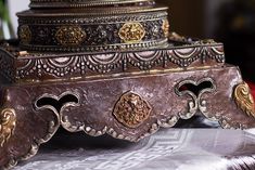 an ornately decorated metal box sitting on top of a table