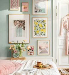 a bedroom with pictures on the wall and flowers in vases sitting on the bed