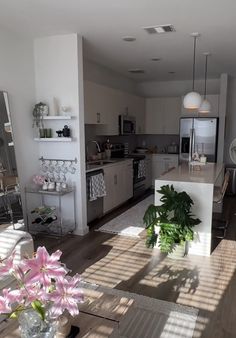 a living room filled with furniture next to a kitchen and dining room table in front of a window