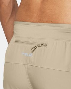 a close up view of the back of a man's body wearing tan shorts