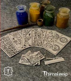 four cards are sitting on the ground next to some jars with colored liquid in them