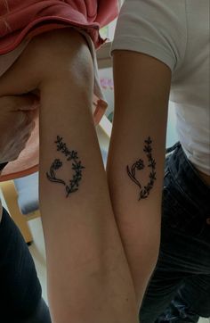 two people with matching tattoos on their arms