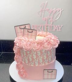 a birthday cake with pink frosting and decorations