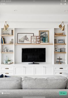 a living room filled with lots of white furniture and bookshelves on top of each other