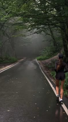 a woman running down the road in the rain