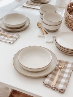 a white table topped with plates and silverware