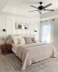 a bedroom with a bed, dresser and ceiling fan in it's centerpiece