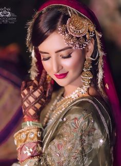 a woman wearing a bridal outfit and jewelry