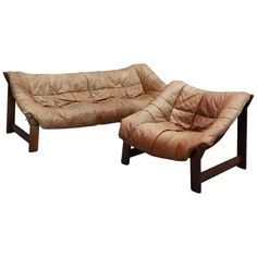 a pair of leather lounge chairs with footstools in the shape of reclinings