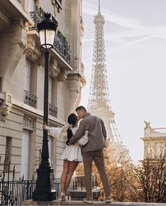 a couple kissing in front of the eiffel tower