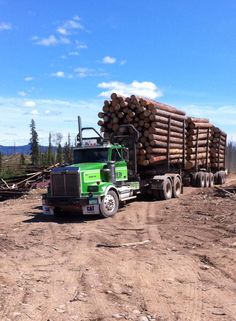 a large truck hauling logs on a dirt road