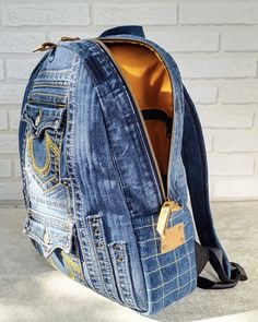 a blue jean backpack sitting on top of a cement floor