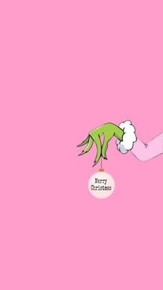 a pink background with a green hand reaching for something