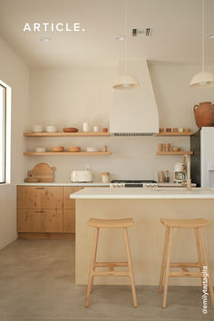 two wooden stools sit in front of an island