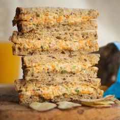 three pieces of bread stacked on top of each other next to chips and a glass of orange juice