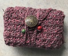 a crocheted purse with a button on the front and two buttons in the middle