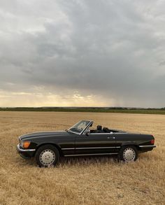 a black convertible car parked in a field