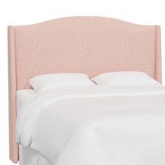 an upholstered headboard for a bed with white sheets and pink linens