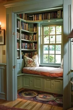 a window seat in the corner of a room with bookshelves on either side