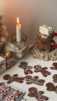 a table topped with lots of cookies next to a lit candle