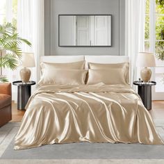 a bed with beige sheets and pillows in a room