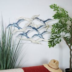 there is a hat on the table next to a potted plant and a wall sculpture