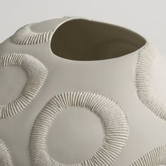 a white vase with circular designs on it