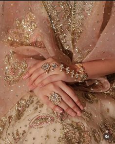 a close up of a person's hands wearing jewelry