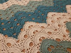 crocheted doily on the ground with brown and blue circles in it's center