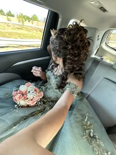 a woman sitting in the back seat of a car wearing a dress with flowers on it