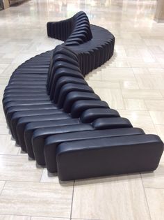 a curved bench sitting on top of a tiled floor