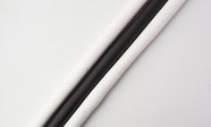 two black and white chopsticks sitting next to each other on a white surface