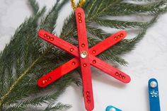 an ornament made out of popsicle sticks and bead trimmings