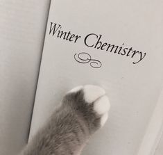 a cat paw on top of a book with the words winter chemistry written above it