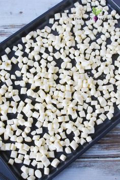 there are many cubes of white food on the tray and one is cut up