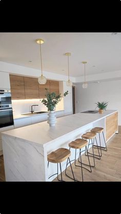 a kitchen island with four stools in front of it