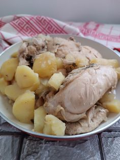 a white bowl filled with meat and potatoes