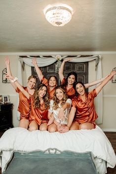 the bride and her bridesmaids are posing on their bed