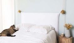 a cat laying on top of a white bed