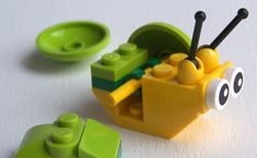 a yellow and green toy car sitting on top of a white table