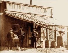 an old photo of three men standing in front of a building