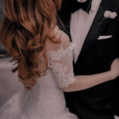 the bride and groom are standing close to each other in their tuxedo attire